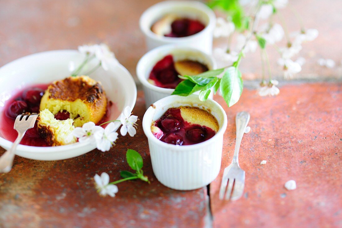 Cherry soufflés in ramekins and in a dessert bowl with stewed cherries