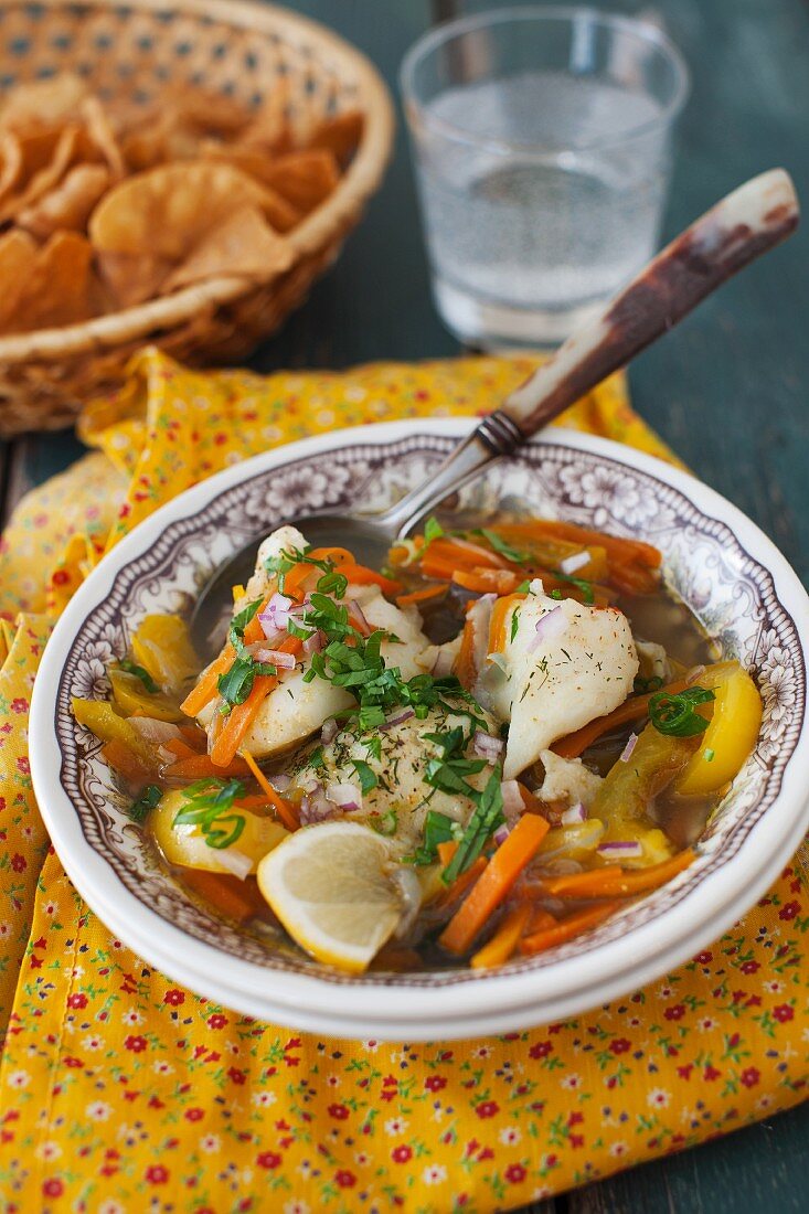 A Bowl of Fish Stew with Carrots and Yellow Bell Pepper