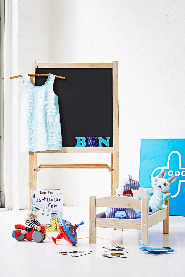 Kinderzimmer mit Puppenbett, Spielzeug und Standtafel