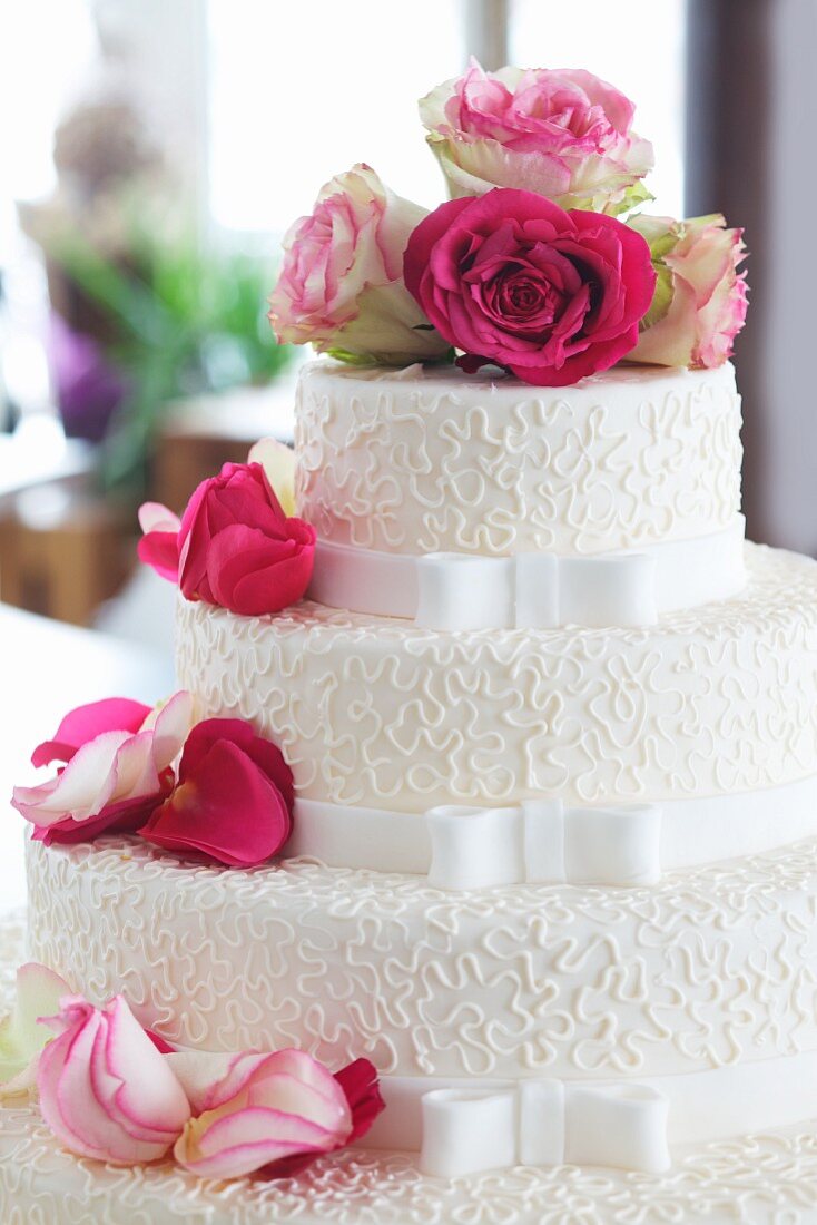 Elegante Hochzeitstorte dekoriert mit frischen Rosen