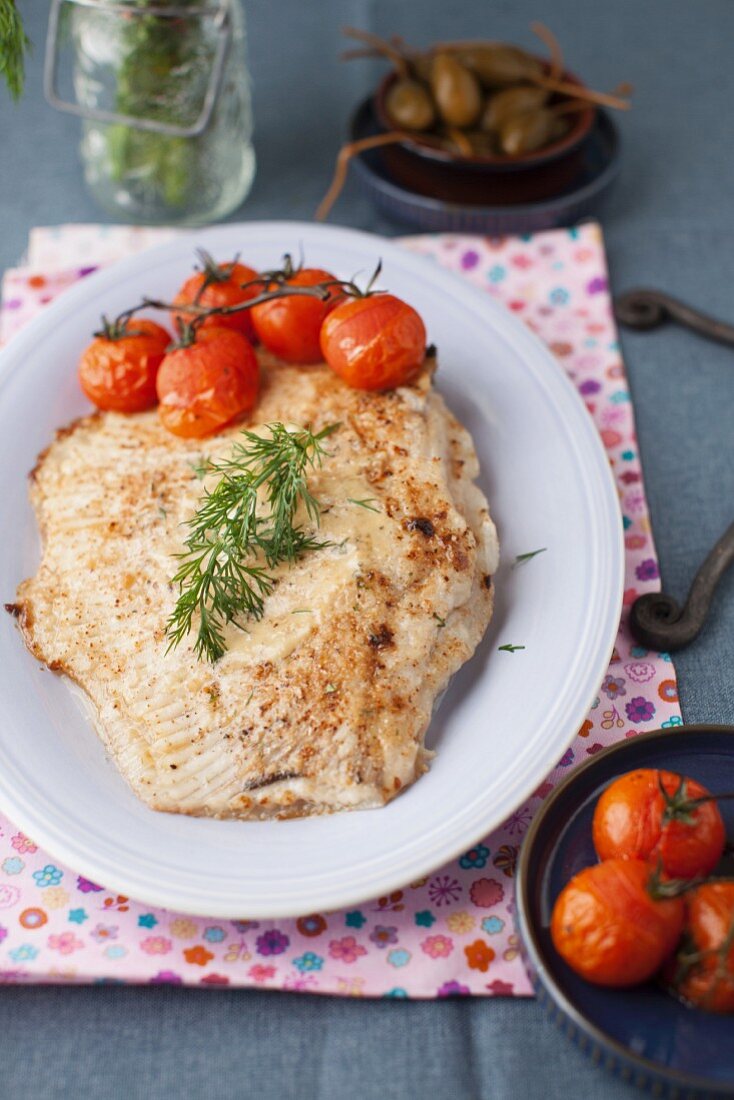 Gebratener Rochen mit Tomaten auf weißem Teller