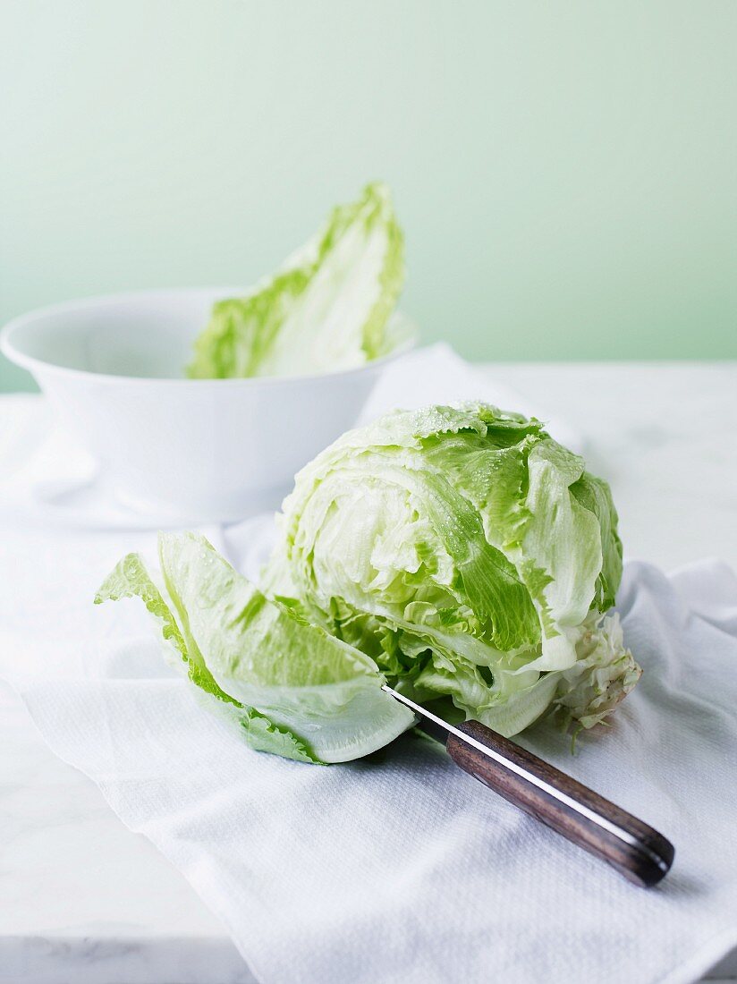 An iceberg lettuce being cut