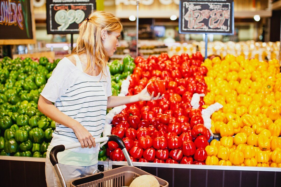 Frau kauft Paprikaschoten im Supermarkt