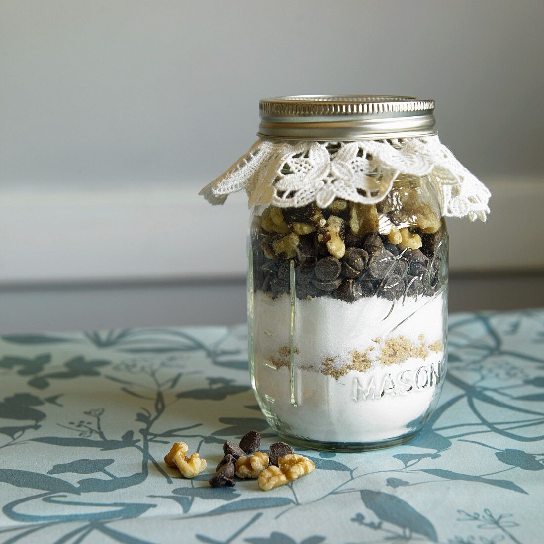 A jar containing dry ingredients for making walnut chocolate chip cookies