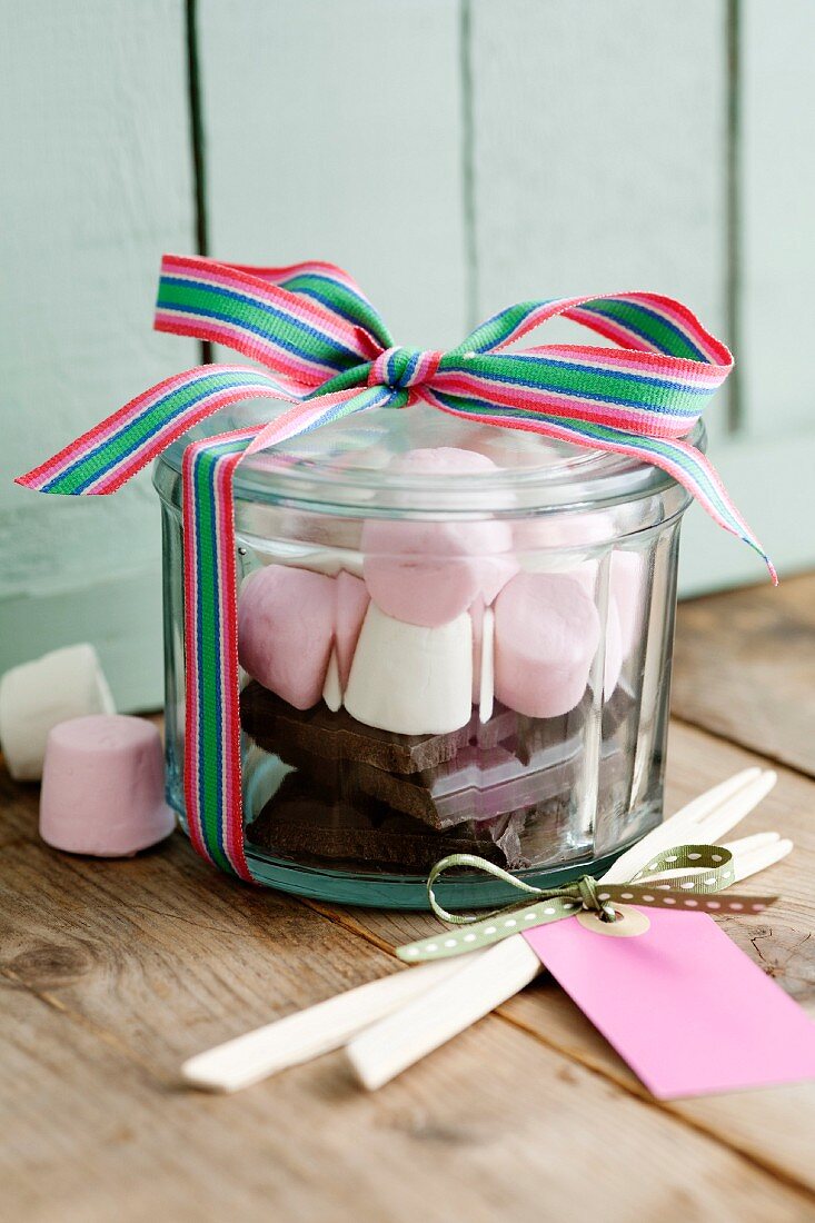 Schokoladenstücke und Marshmallows in einem Glas als Geschenk