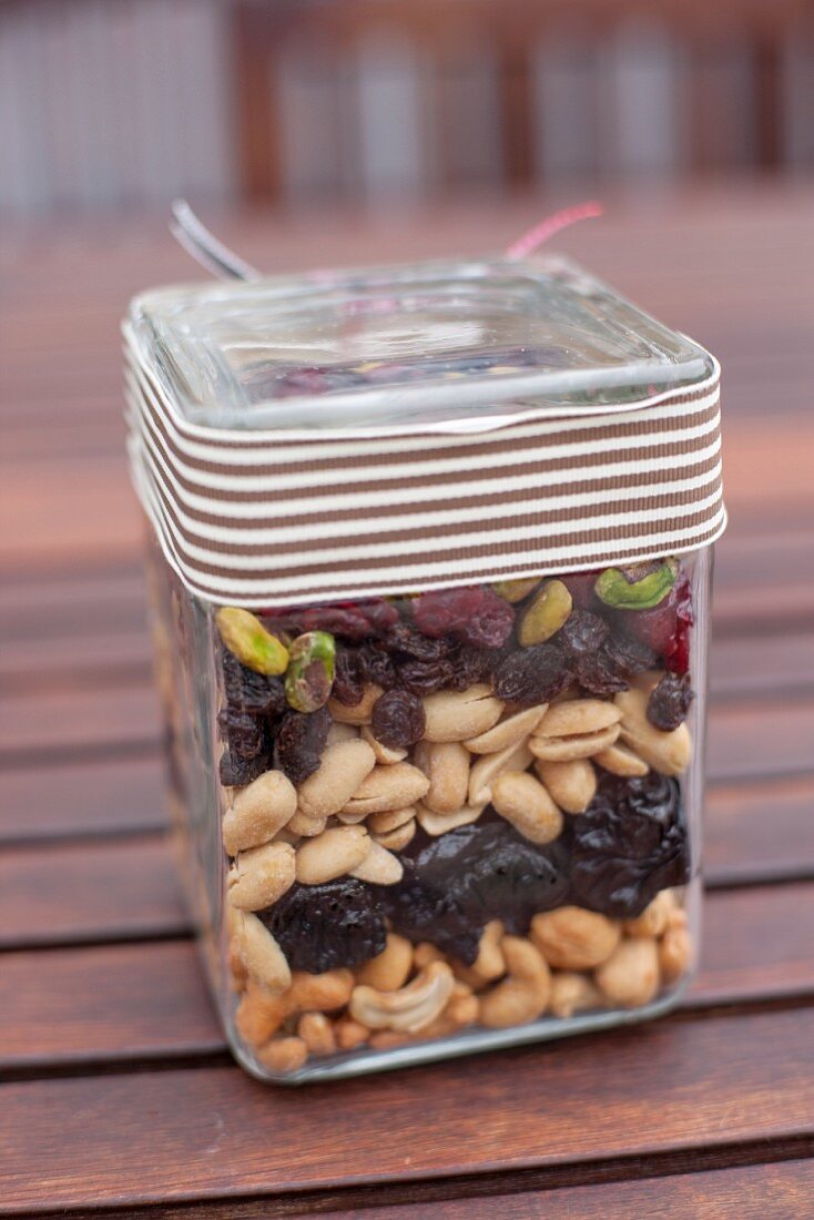 Assorted nuts and raisins layered in a jar as a gift