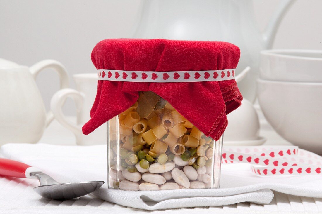 Trockene Zutaten für Hülsenfrüchtesuppe mit Nudeln in einem Geschenkglas