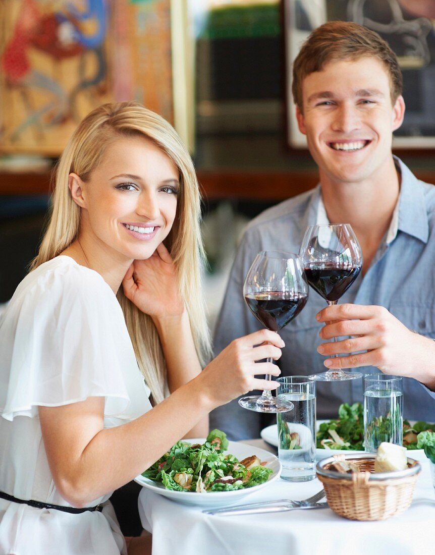 Junges Pärchen mit Rotwein beim Mittagessen im Restaurant