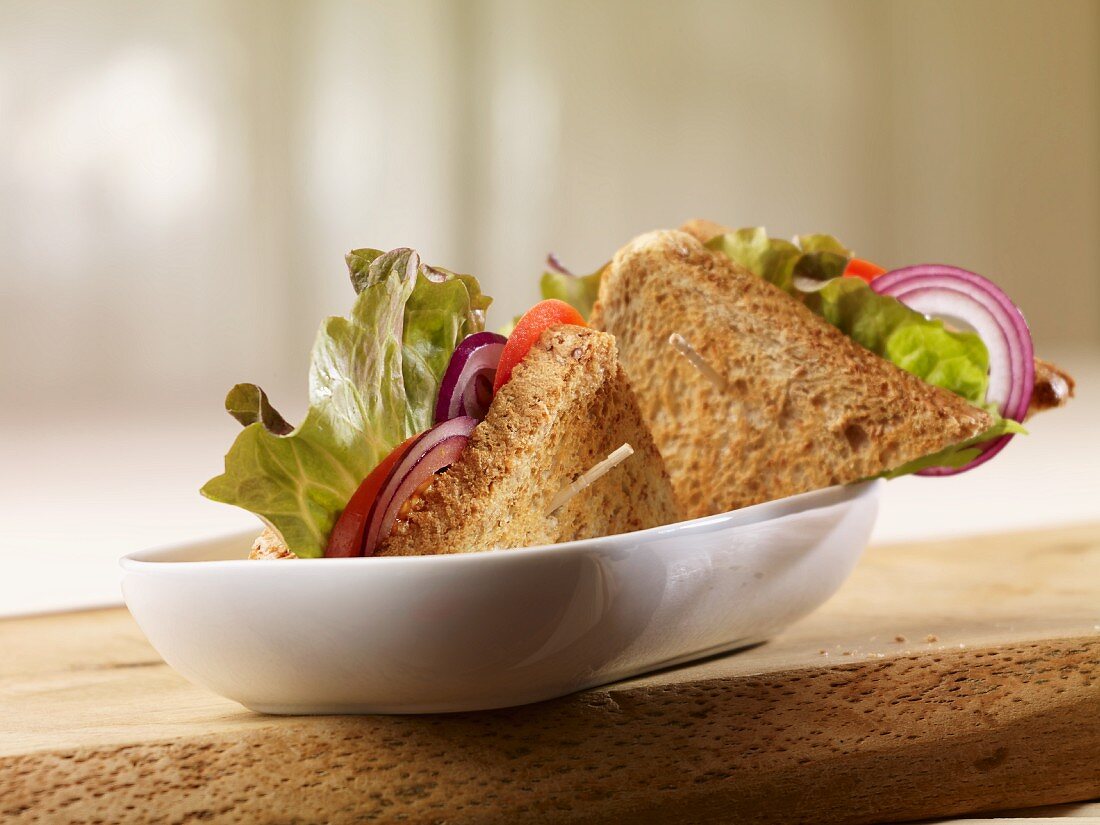 Wholegrain bread sandwich filled with batavia lettuce, onion rings and tomatoes