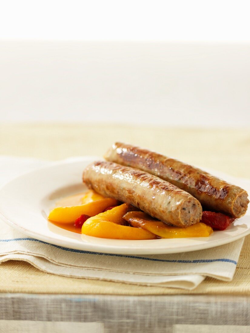 Bratwurst sausages on a bed of peppers