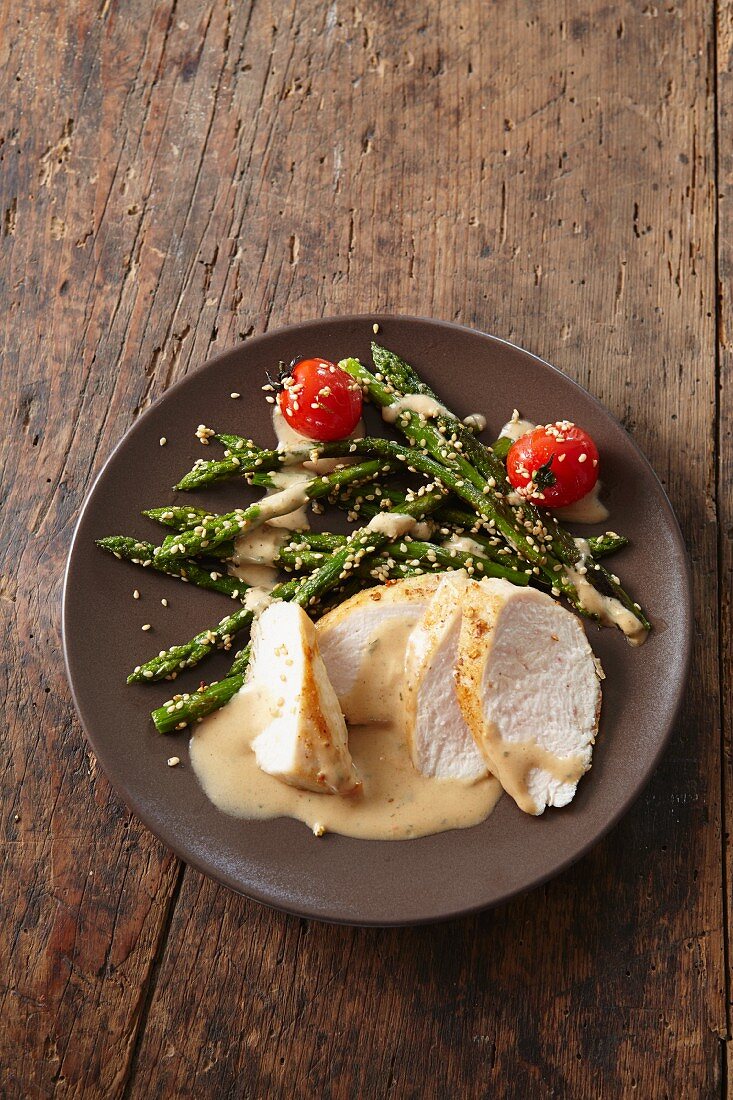 Chicken breast in a mustard sauce with asparagus and sesame seeds