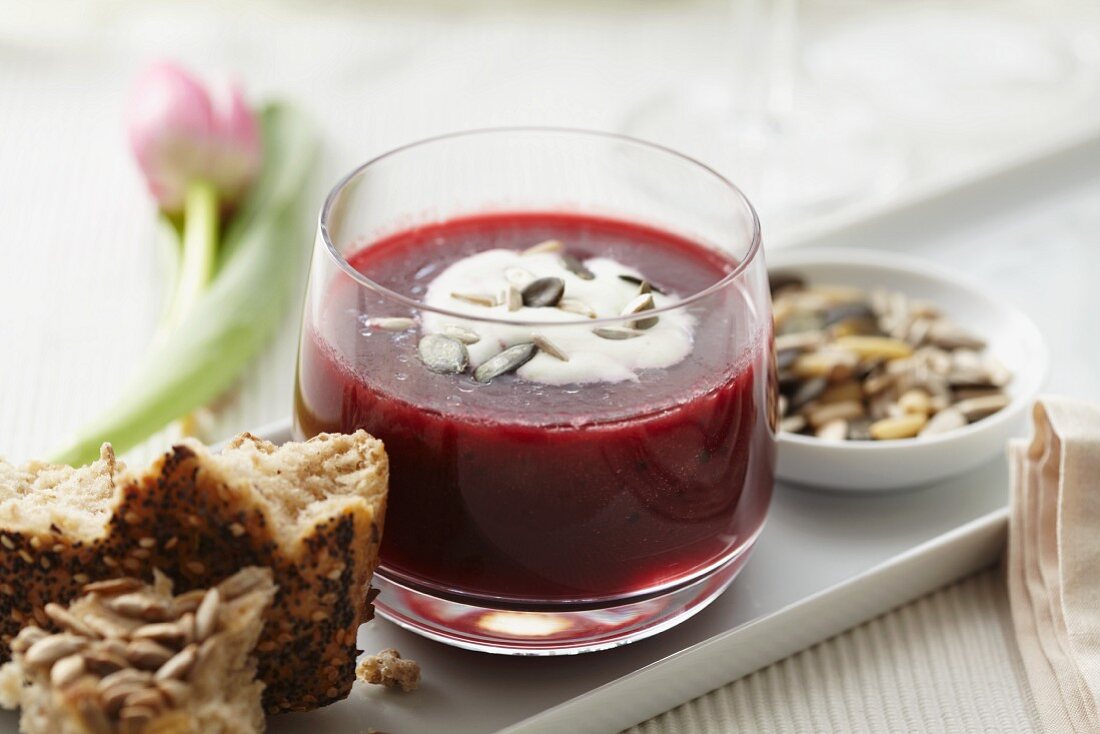 Bowl of Beet Soup with a Dollop of Sour Cream Garnished with Fennel; From Above