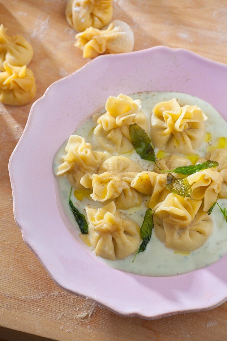 Fiocchi (filled dumplings) with Gorgonzola and pear filling, on herb sauce