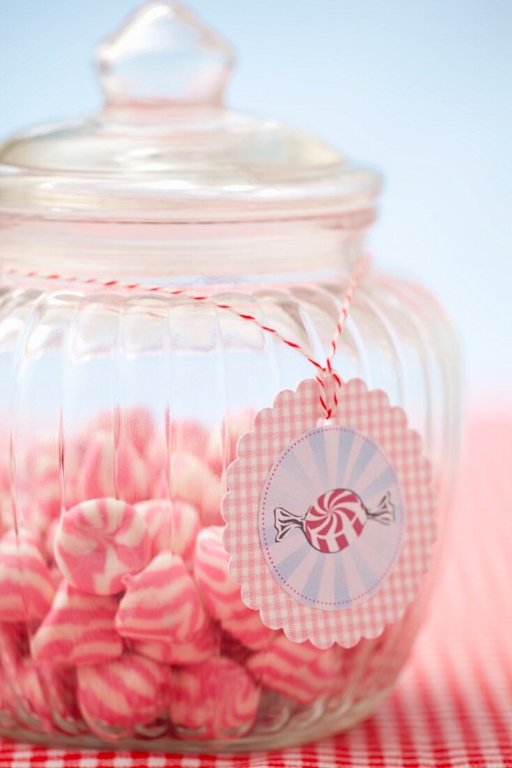 A jar of pink and white striped sweets