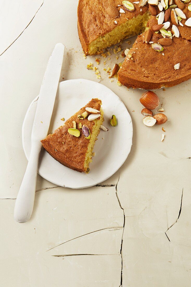 Lemon cake with almonds and pistachios, one slice cut