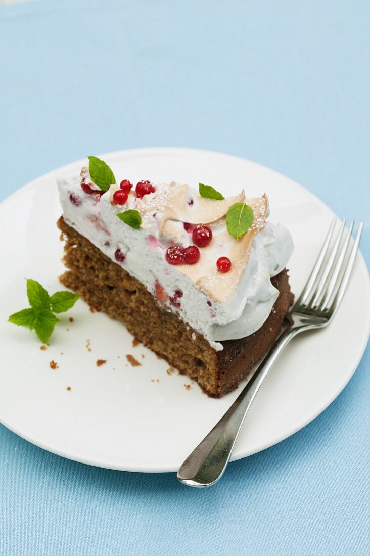 A slice of redcurrant cake with meringue topping and mint