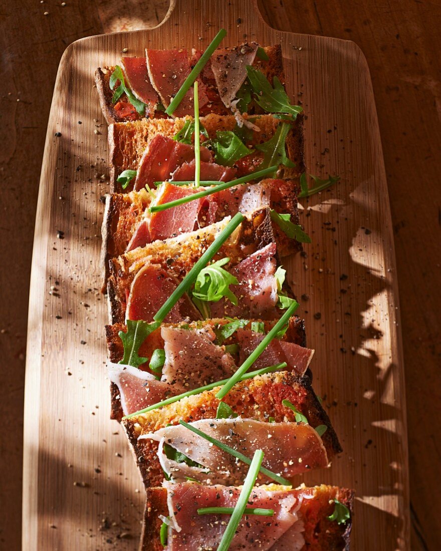 Toasted slices of bread with Corsican ham and chives