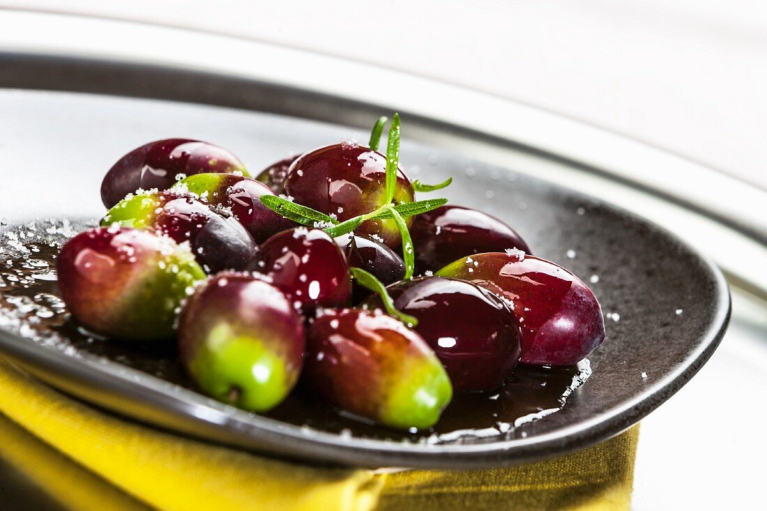 Grün-rote Oliven auf Teller