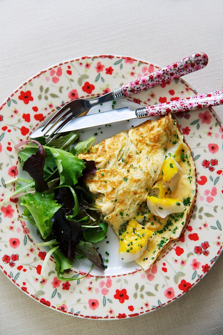An omelette with smoked fish and salad