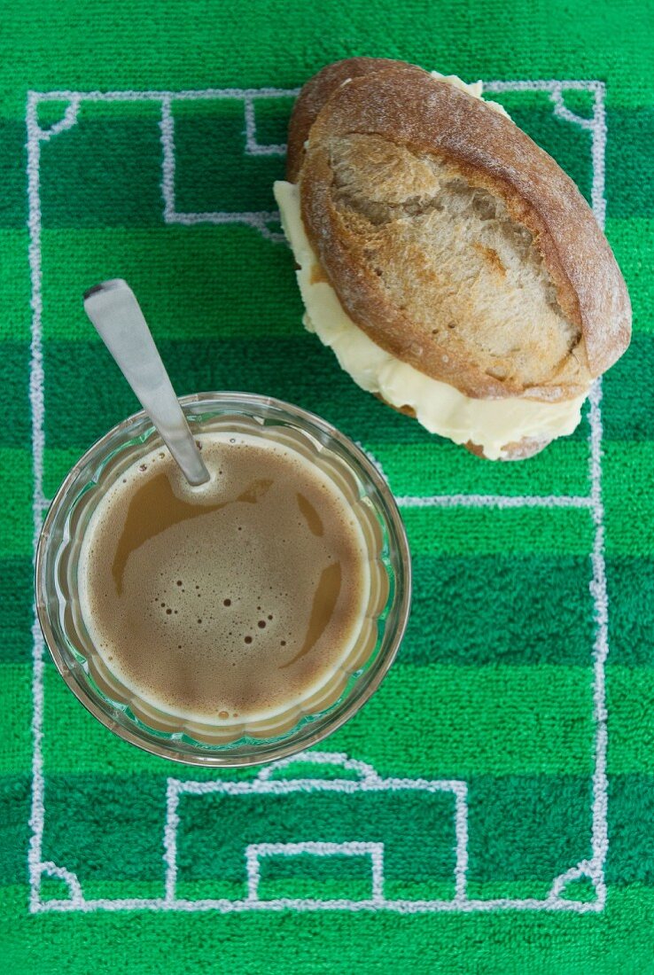 A breakfast of coffee and a bread roll (Brazil) with football-themed decoration