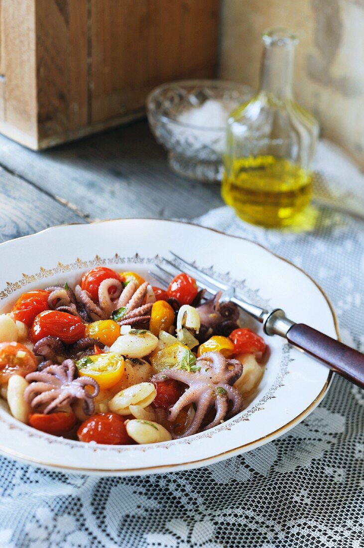 A salad made from white beans, cocktail tomatoes and baby octopus