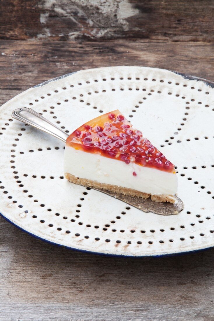 A slice of cheesecake with pomegranate jelly