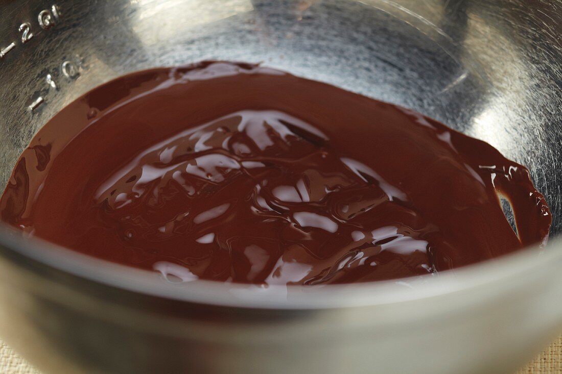 Geschmolzene Schokolade in einer Metallrührschüssel (Nahaufnahme)