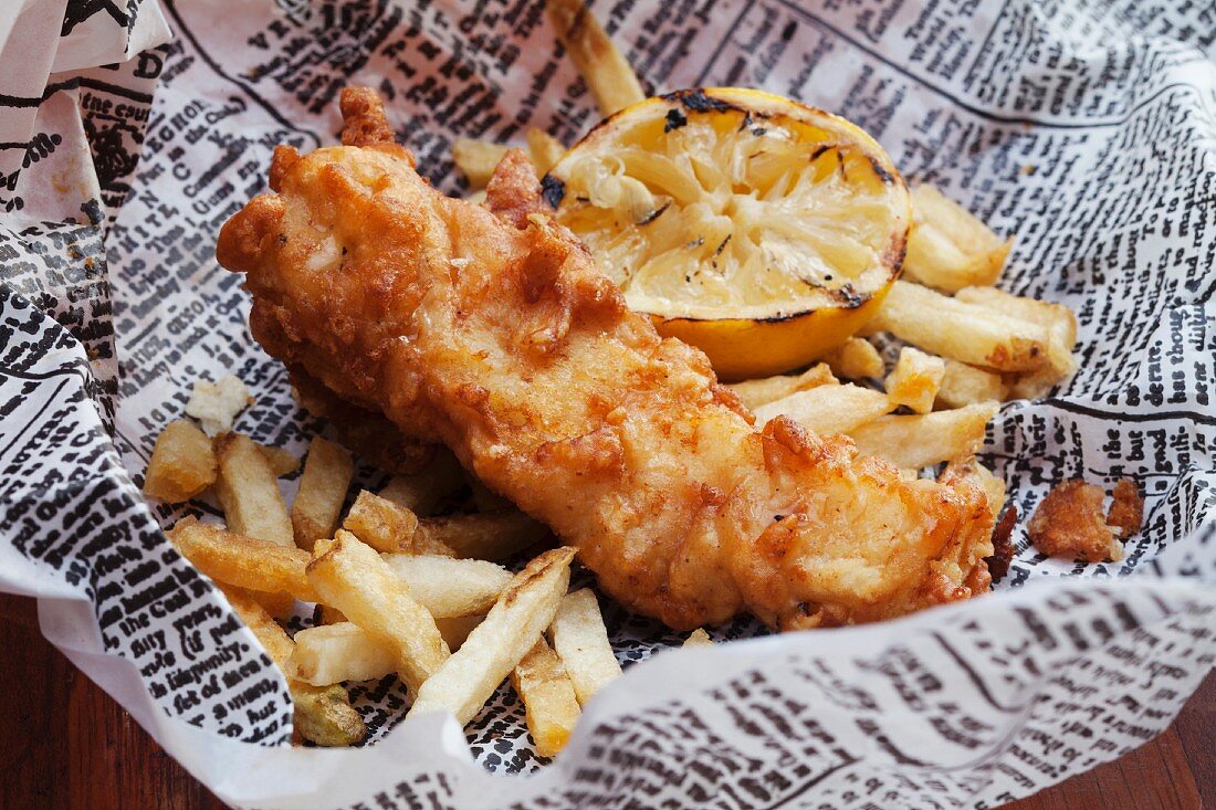 Fish And Chips mit Zitrone auf einer Zeitung