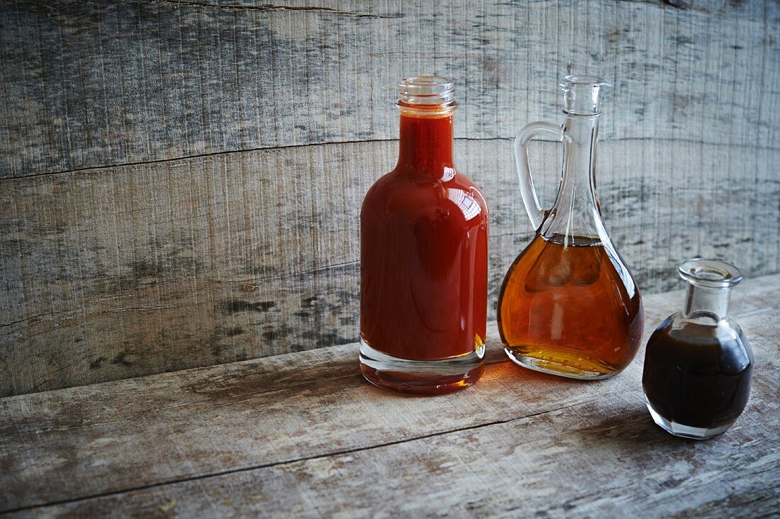 Verschiedene Saucen mit fassgereiftem Bourbon: scharfe Essigsauce, Ahornsirup und Worcestersauce