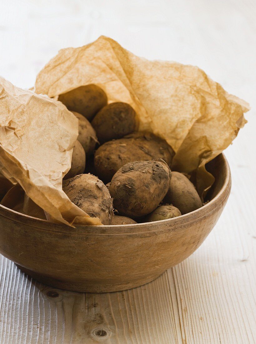 Frische Kartoffeln auf braunem Papier in einer Schüssel