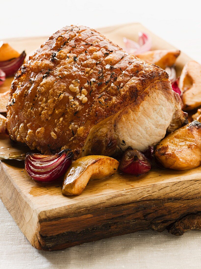 Roast crackling pork with quinces and onions