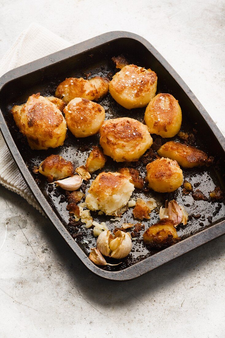 Roast potatoes with garlic in a baking tray