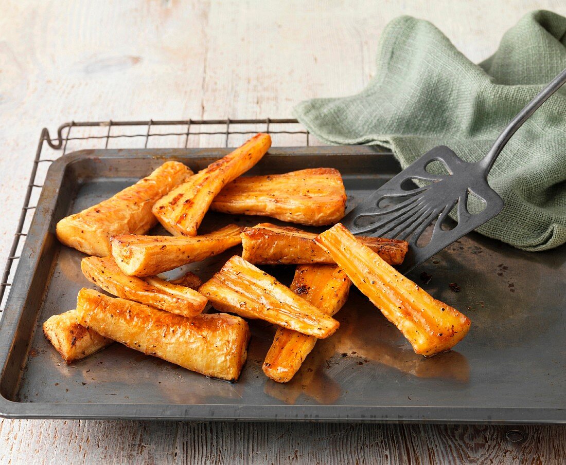 Honey roast parsnips on baking tray with green cloth