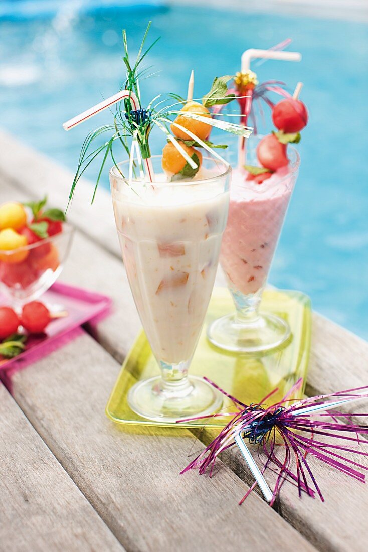 Two fruity cocktails by the pool