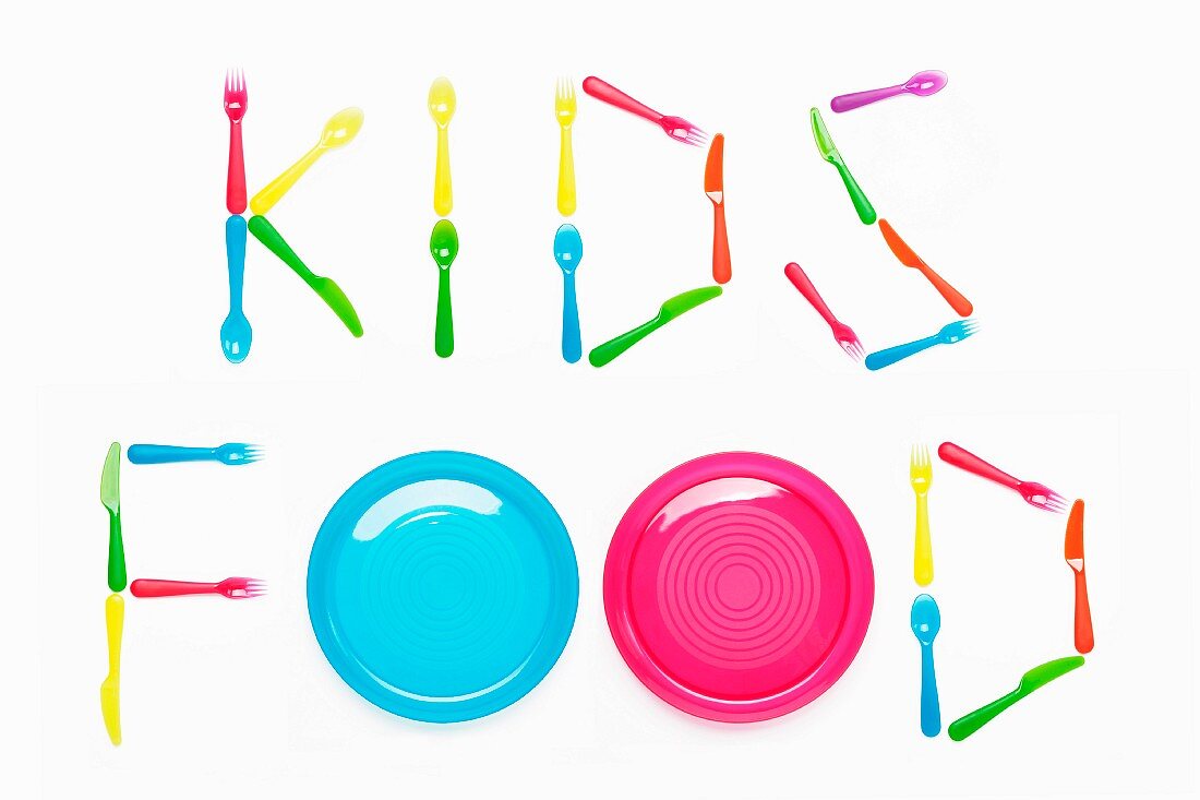 KIDS FOOD written with plastic cutlery and plates