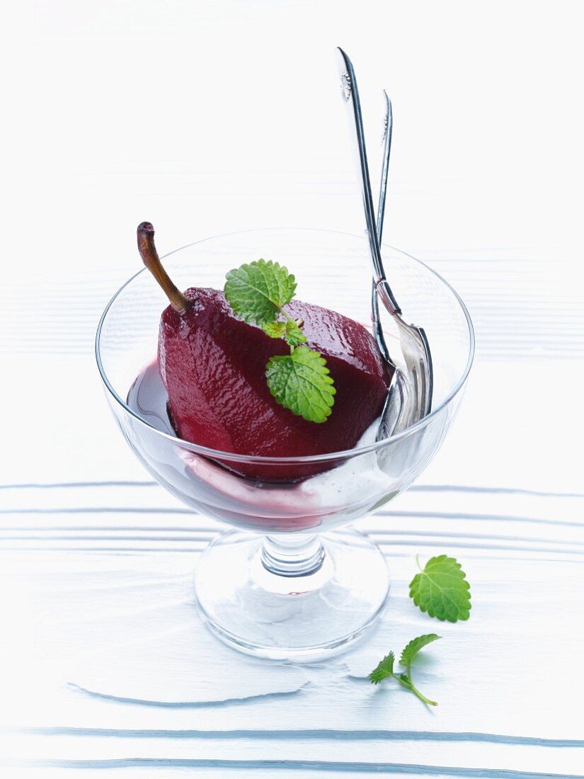 A pear poached in red wine and served with vanilla cream