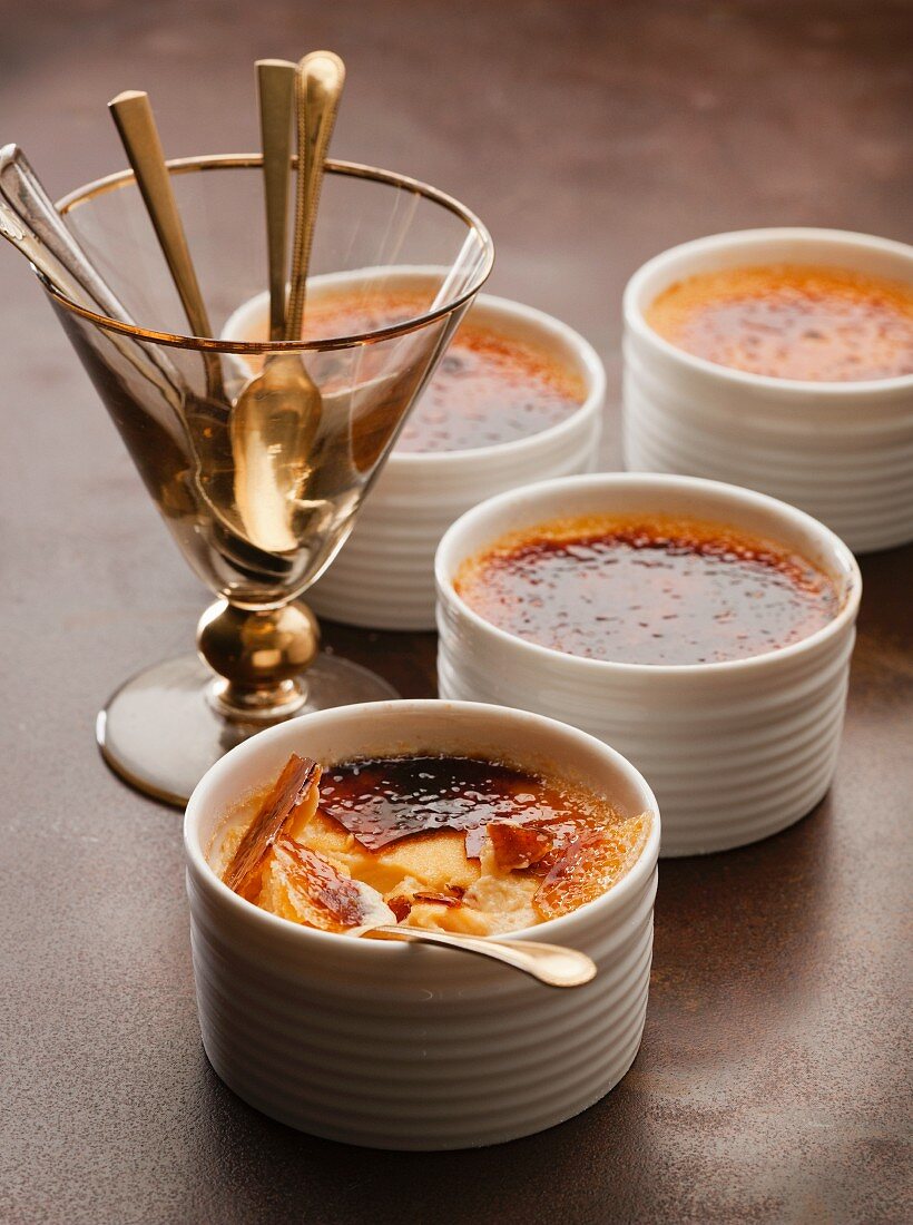 Crème brûlée and a glass holding dessert spoons