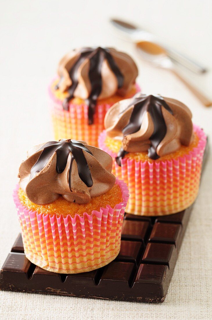Three cupcakes with chocolate buttercream topping