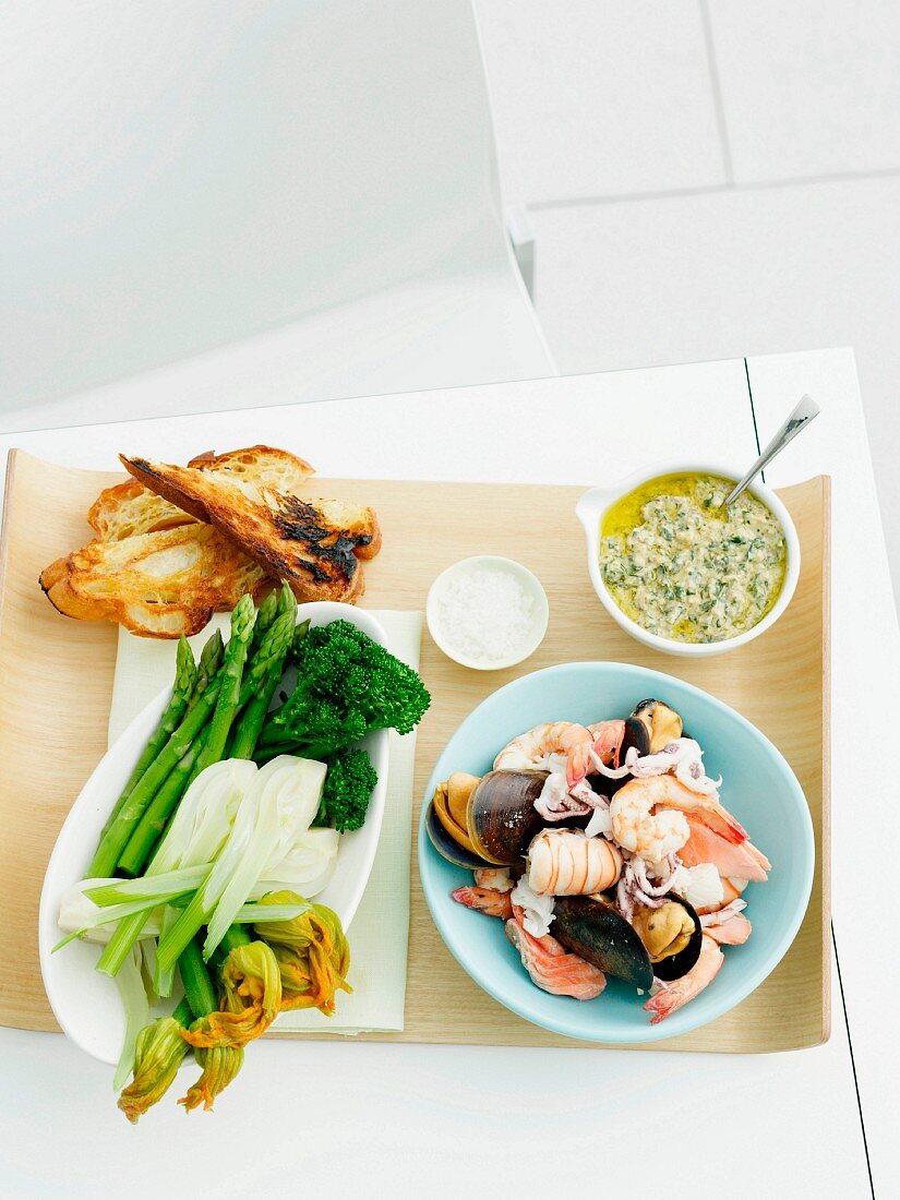 Rohkostplatte mit Röstbrot, Meeresfrüchten und Salsa verde