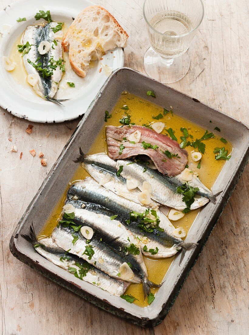 Eingelegte Sardinen mit Olivenöl, Knoblauch und Kräutern
