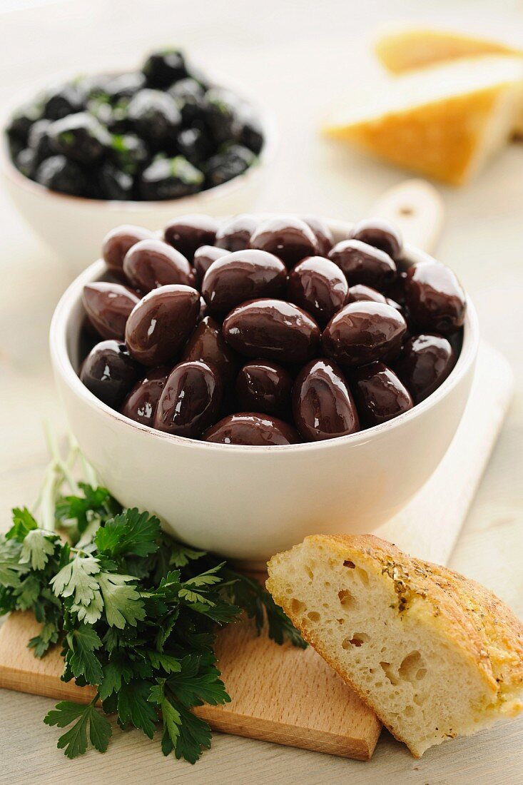 Kalamata olives in a bowl, with parsley and bread