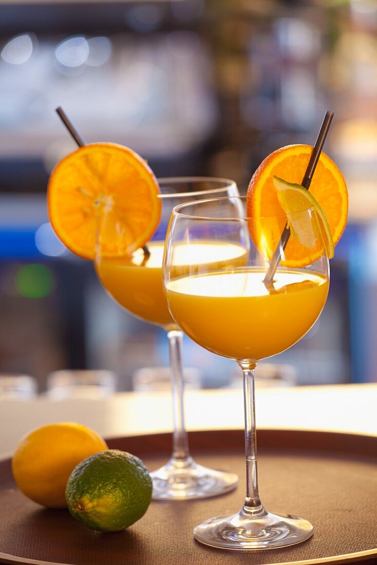 Orangen-Limetten-Drink in zwei Weingläsern