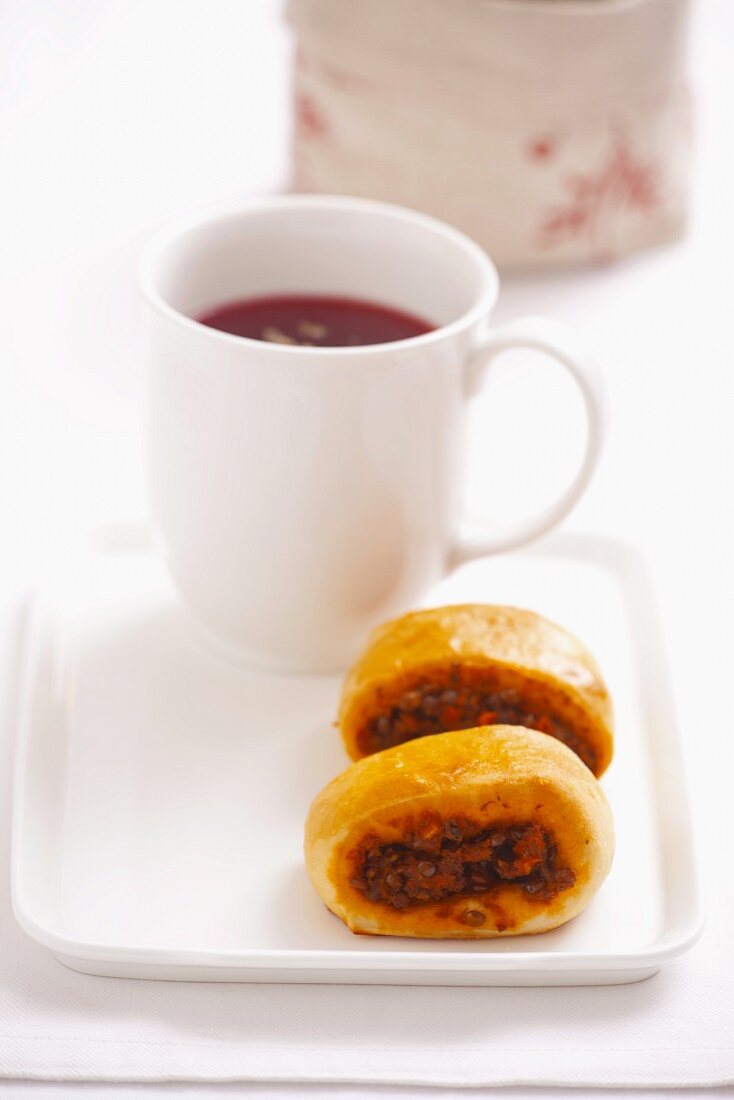 Yeast-risen pastries with lentil and tomato filling, served with a mug of borscht