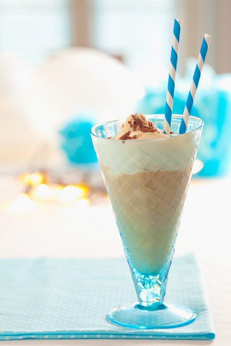 A chocolate milkshake with vanilla ice cream and chocolate shavings