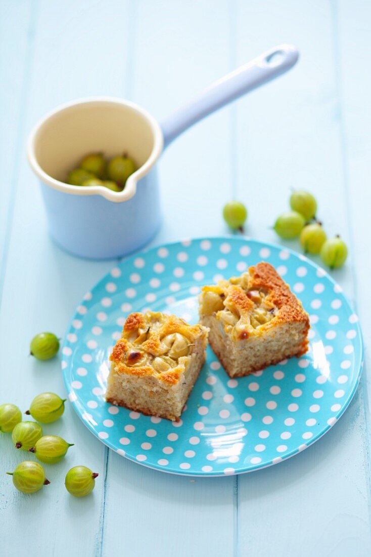 Two pieces of gooseberry cake on a spotted plate