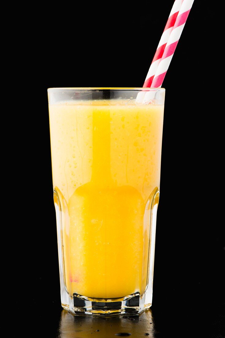 A glass of orange juice with bits of pulp