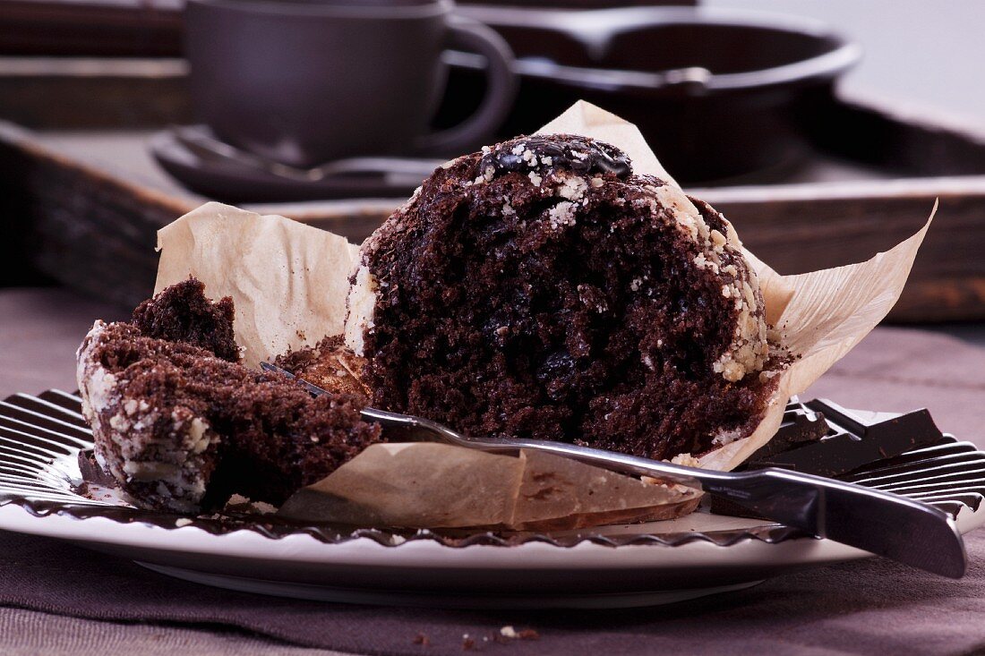 A chocolate muffin, partly eaten