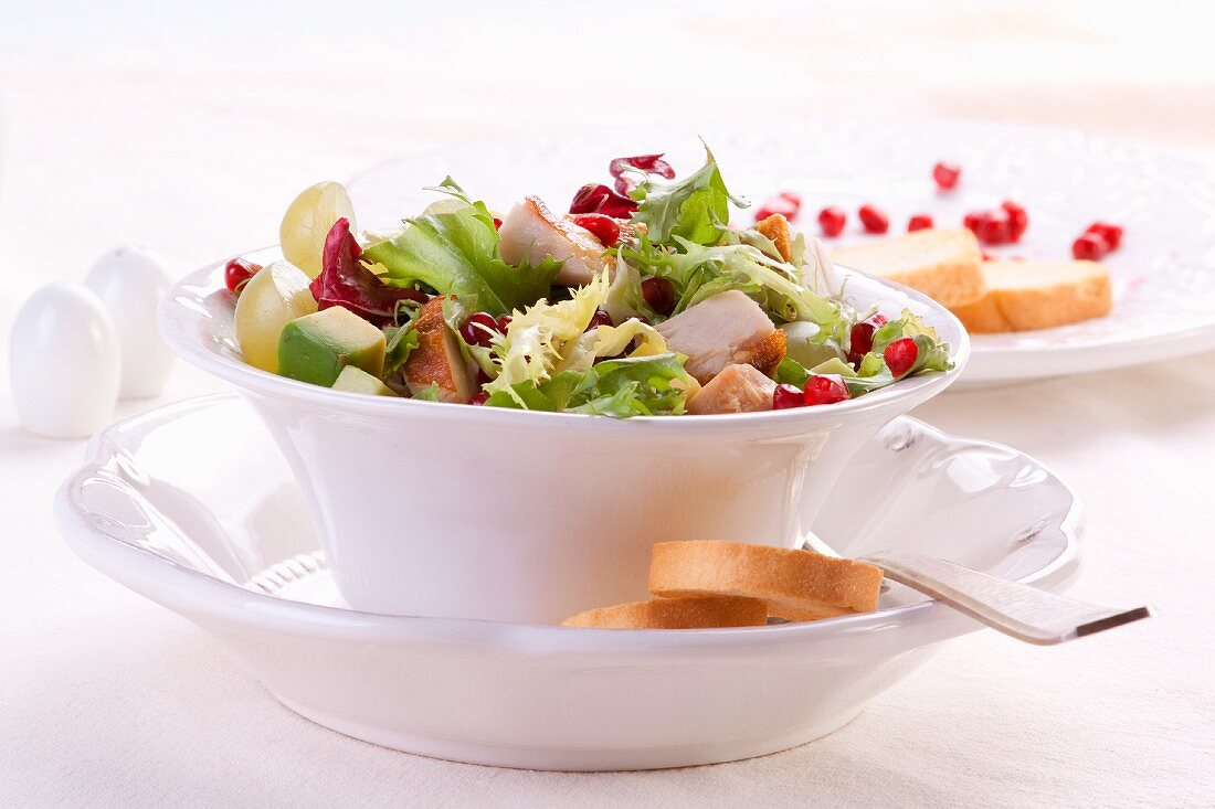 Salad leaves with chicken, avocado, pomegranate and grapes