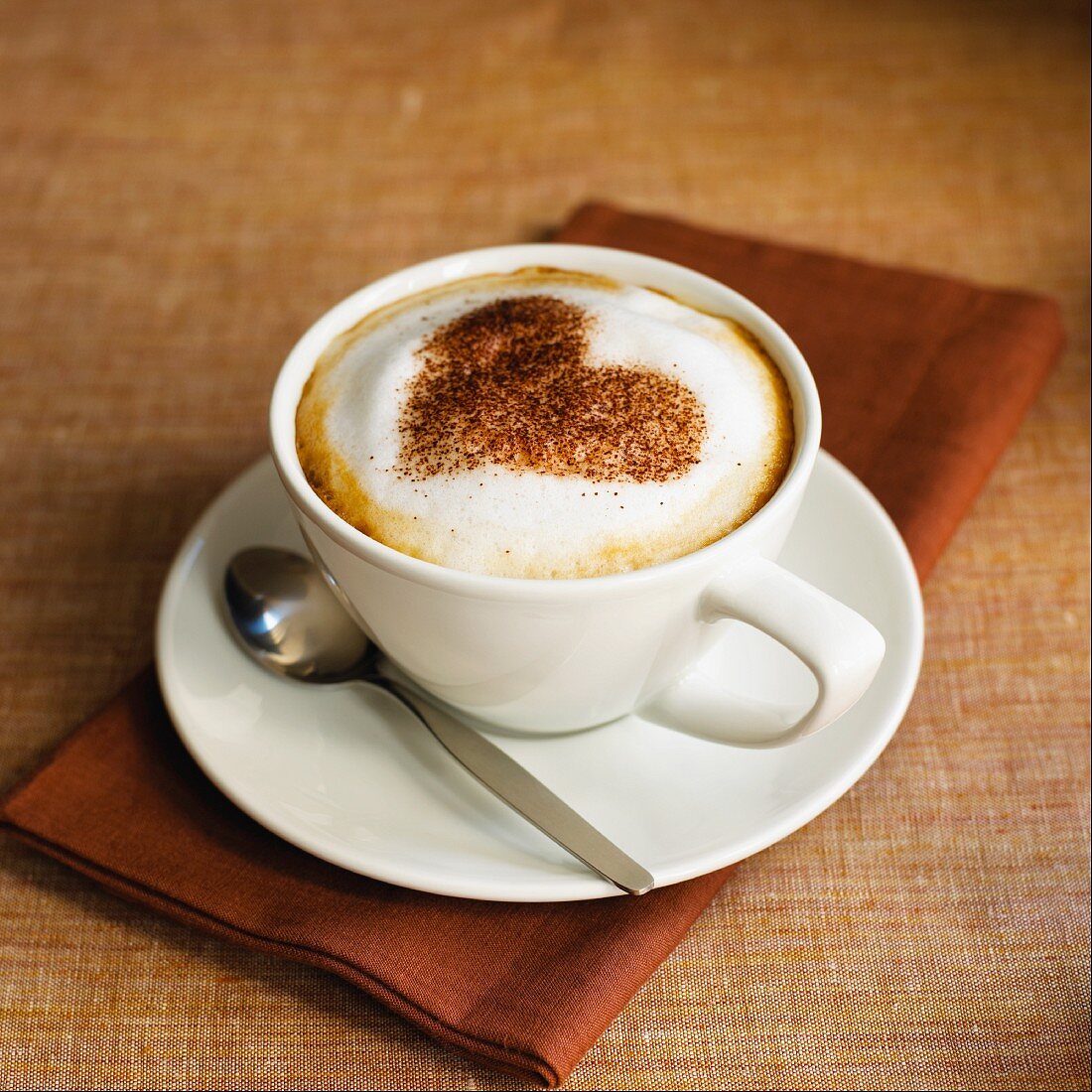 A cup of Cappuccino with heart shape from cocoa powder