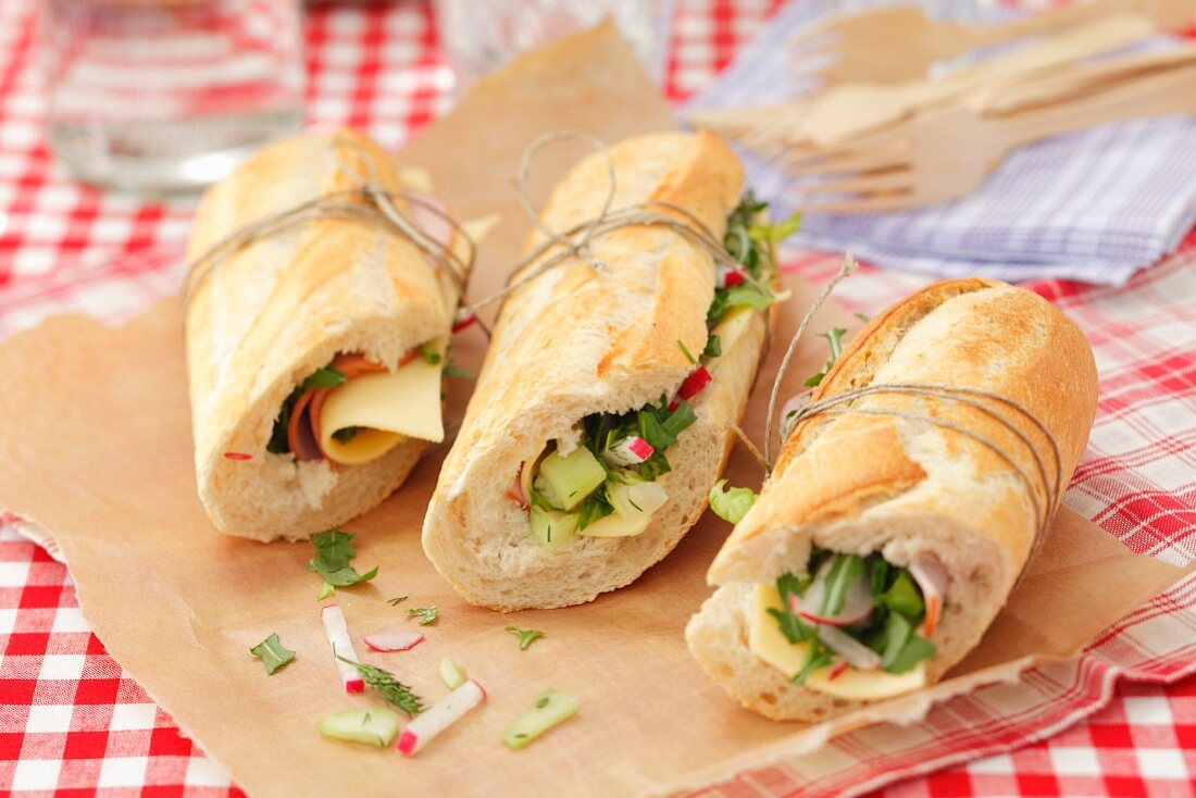 Baguette sandwich filled with cheese, ham and vegetables